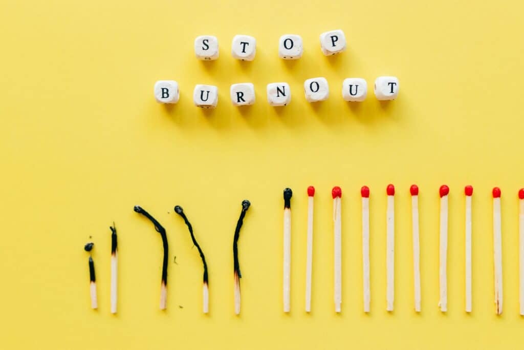 pexels-photo-6837572-6837572-1 Conceptual image of burnout prevention with matches and letters on yellow background.